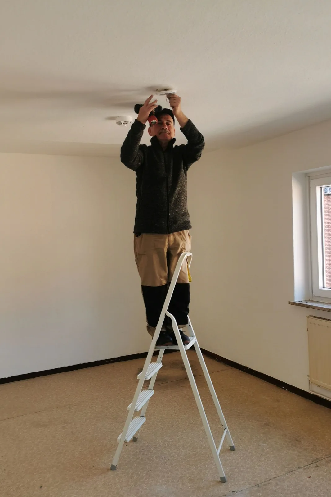 Fitting a ceiling detector from a step ladder, for ceiling fan installation in Toronto